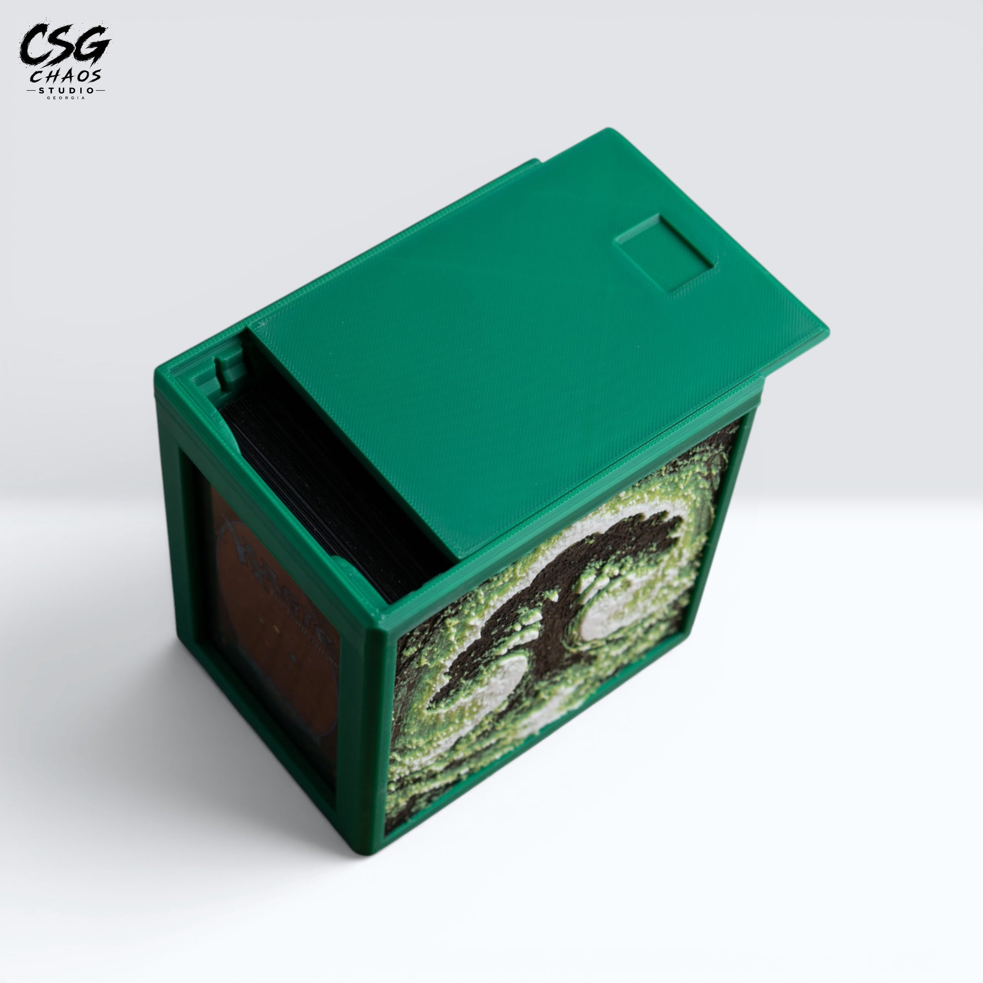 MTG Commander deck box with the green lid slid open, cards visible inside and forest side art — Chaos Studio Georgia