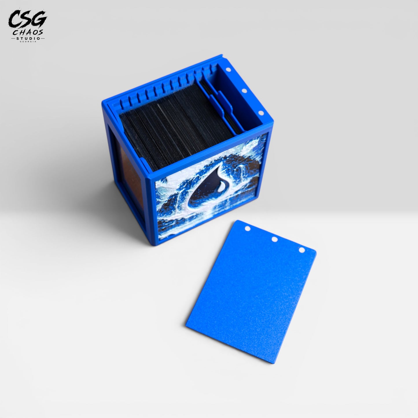 MTG Commander deck box with lid removed beside it, showing the internal divider and blue frame — Chaos Studio Georgia