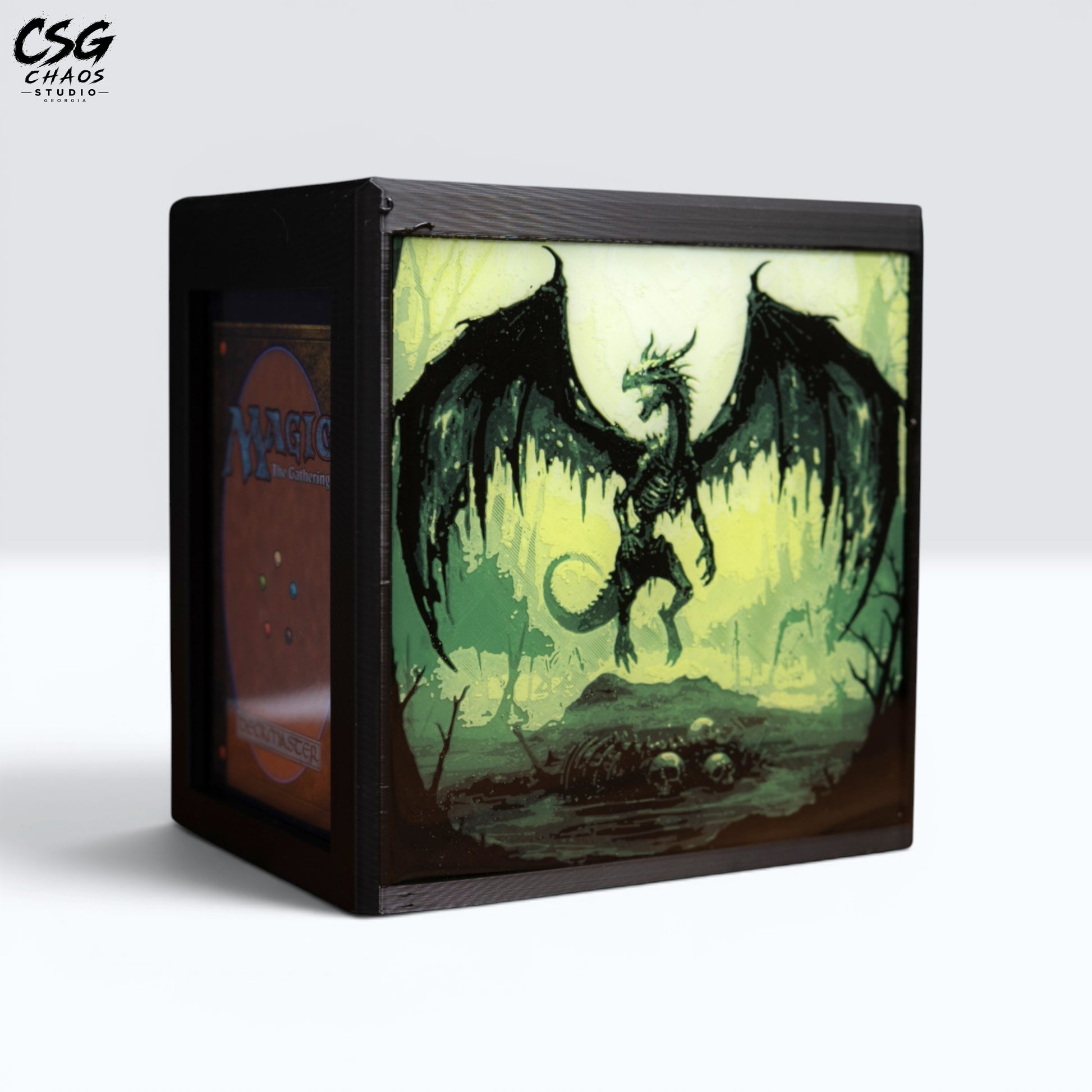 MTG Commander Deck Box PRISM Series, straight-on front view with skeletal winged dragon over skull-strewn swamp — Chaos Studio Georgia